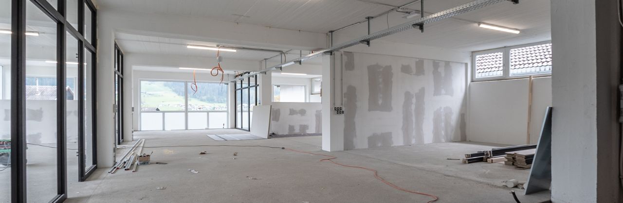 Glanzhelden – Bauendreinigung – Uelzen Rohbau eines modernen Hochhausetagenraums Sichtbetondecke und verschiedenen Arbeitsmaterialen