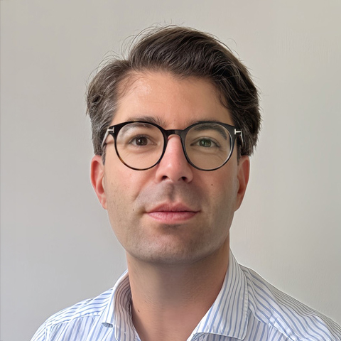 JM_glanzhelden_02 Porträt eines Mannes mit dunklen Haaren und Brille, der ein helles Hemd trägt